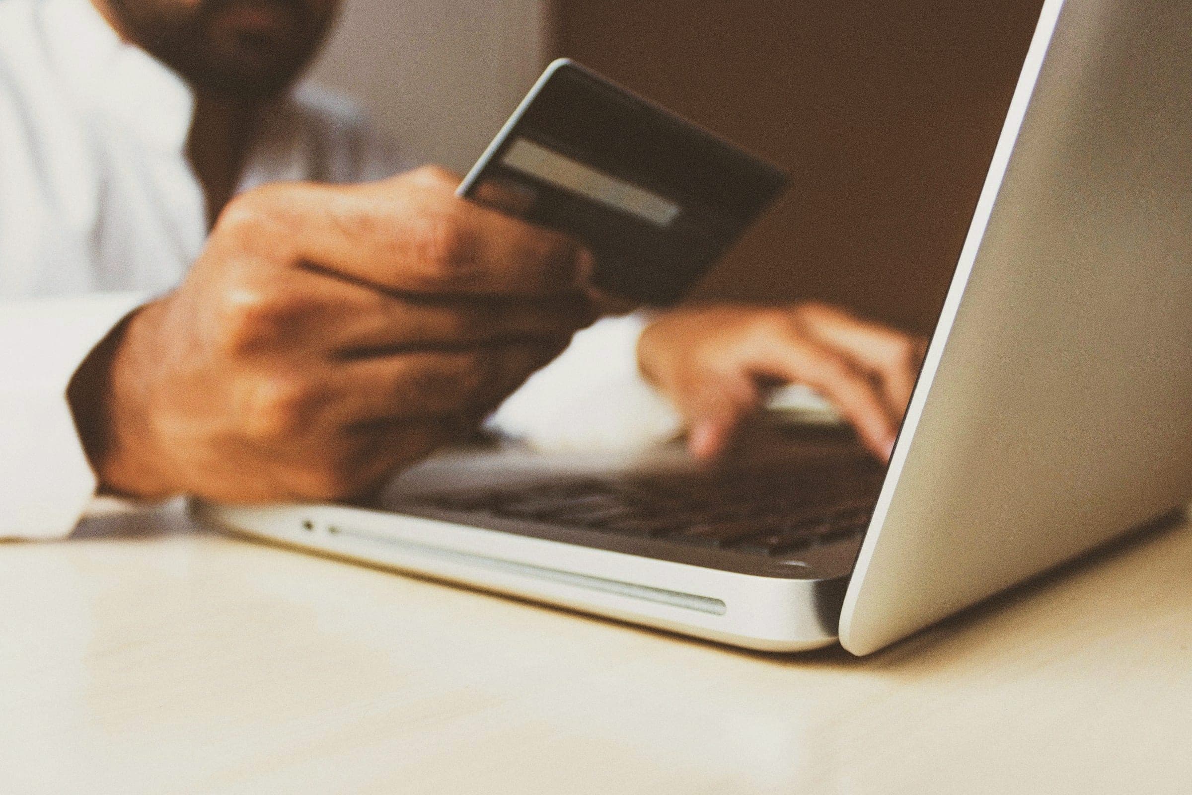 Someone paying online with a card on a laptop